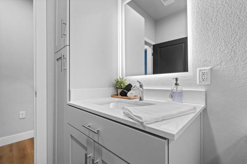 a white bathroom with a sink and a mirror at Relax In Style Cozy 1br W Pool, Gym & Free "p" in Rogers