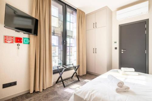 a bedroom with a bed and a tv and a window at Casa Española in Ath