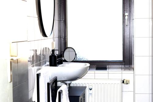 a bathroom with a white sink and a mirror at ASYA HOME Zentral, Balkon, Netflix, Gratis Kaffee und Tee in Chemnitz