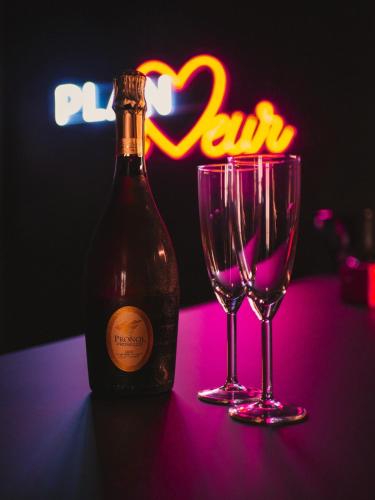 une bouteille de vin et deux verres sur une table dans l'établissement PLAN COEUR Romantic Experience & Spa, à Riom