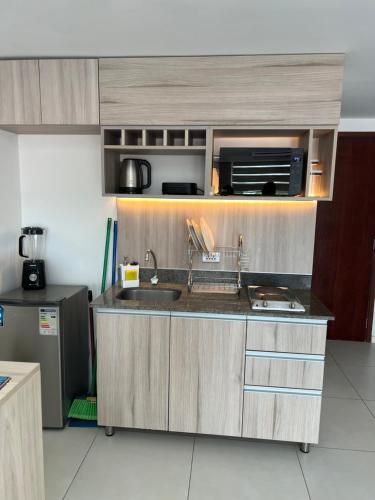 a kitchen with a sink and a microwave at ZONA VIP elegante y comodo APARTAMENTO FAMILIAR CON BALCON y hermosa vista a la calle, canal isuto zona equipetrol in Santa Cruz de la Sierra