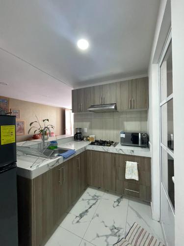a kitchen with wooden cabinets and a counter top at Santuario De Luna, Departamento in Cholula