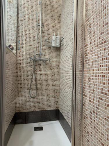 a bathroom with a shower with a tiled wall at CASA CON FINCA PRIVADA in Moaña