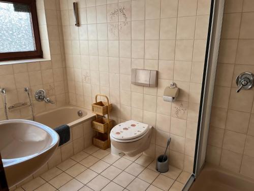 a bathroom with a tub and a toilet and a sink at Wohnung in Feldrandlage in Massenbachhausen