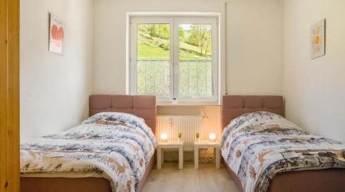 two beds in a small room with a window at Traumurlaub in Sicht! 77qm Familiendomizil in Münstertal