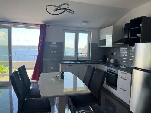 a kitchen with a table and chairs with a view at Apartments Dobrila in Zavala