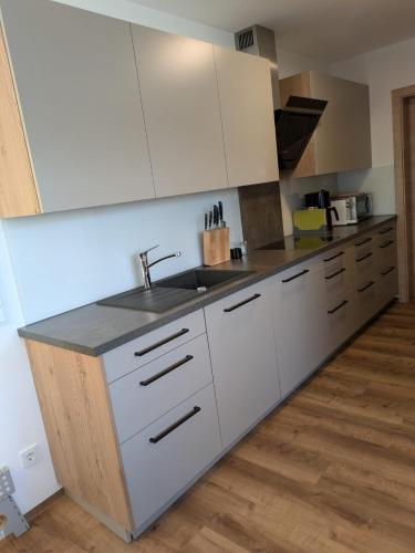 a kitchen with white cabinets and a sink at Apartment Bergland in Sankt Johann im Pongau