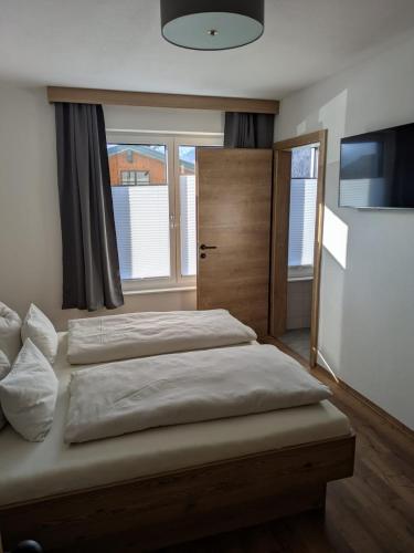 a bedroom with two beds and a large window at Apartment Bergland in Sankt Johann im Pongau
