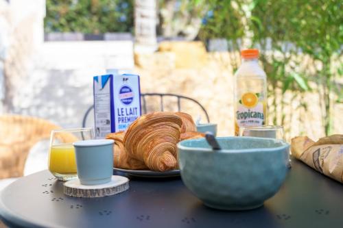een tafel met een bord brood en een schaal sinaasappelsap bij L'Inséparable - Jacuzzi - Terrasse - Parking - Vélos in Fondettes