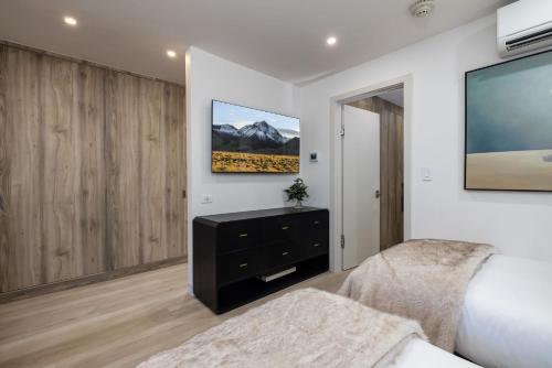 a bedroom with a bed and a tv on the wall at 2 BR 3BA Condo - AC, Heated Pool, Walk to Town in Aspen