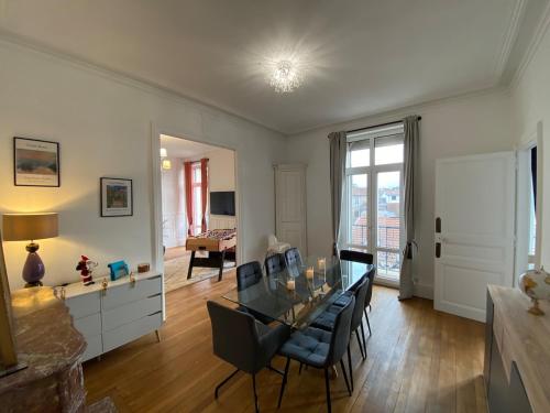 un salon avec une table en verre et des chaises dans l'établissement Beautiful double apt family babyfoot 2 parking, à Nancy