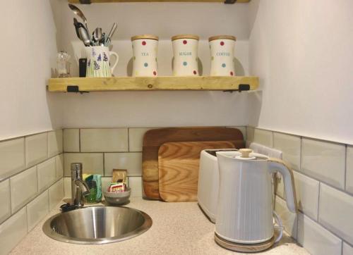 a kitchen counter with a sink and a counter top with a mixer at The Waveney in Keynsham