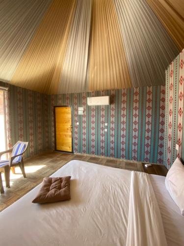 a bedroom with a bed with a towel on it at Wadi Rum Santa Camp in Wadi Rum