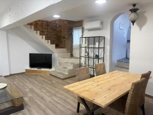 sala de estar con mesa de madera y escalera en Casa Cosmeiro, en Sierra de Outes
