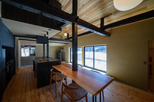 a dining room with a wooden table and chairs at JINEN hida takayama in Machikata