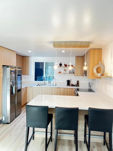 a kitchen with a large white counter and chairs at Old Sunny Hills in Fullerton in Fullerton
