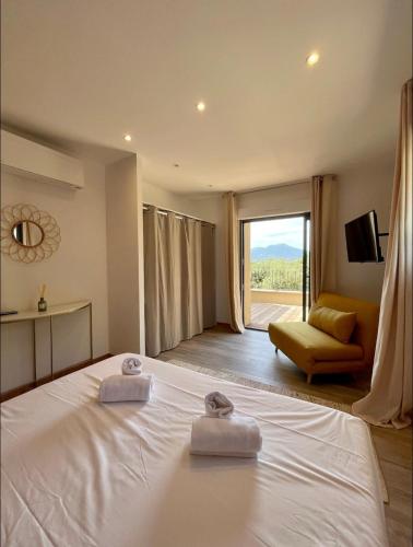 une chambre avec un lit, un canapé et une fenêtre dans l'établissement Maison chaleureuse accès privé à la plage, à Olmeto