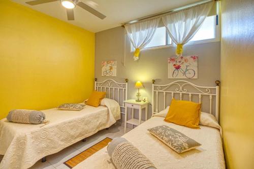 two beds in a room with yellow walls at Apartamento Paraíso Playa in Los Llanos de Aridane