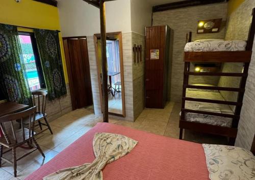 a bedroom with a bed and a bunk room with a ladder at Maresias Hostel & Suites in Maresias
