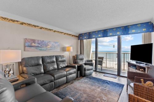 a living room with a couch and a television at Pelican Watch #405 in Carolina Beach
