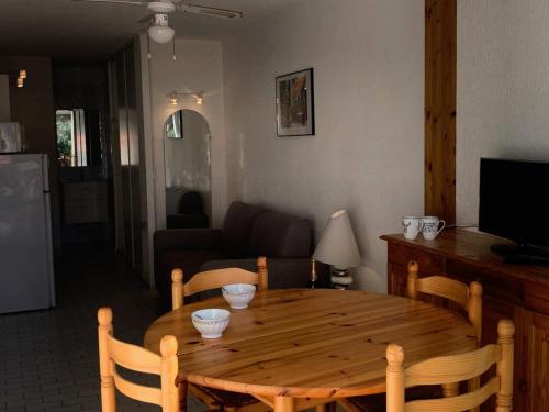 une table et des chaises en bois dans un salon dans l'établissement Résidence Port Nature Colline 4 - Studio 2 pers. - Port Nature Colline 4 MAE-6144, au Cap d'Agde