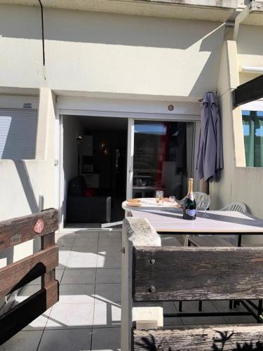 - une table avec une bouteille de vin assise sur une terrasse dans l'établissement Résidence Port Nature Colline 4 - Studio 2 pers. - Port Nature Colline 4 MAE-6204, au Cap d'Agde