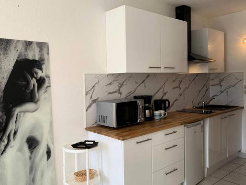 une cuisine avec un comptoir avec un micro-ondes dans l'établissement Résidence Port Nature Colline 4 - Studio 2 pers. - Port Nature Colline 4 MAE-6204, au Cap d'Agde