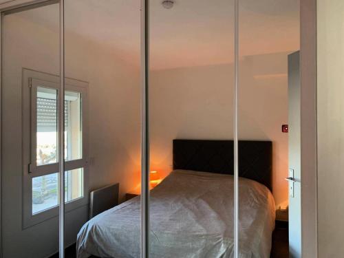 sypialnia z łóżkiem ze szklanymi ścianami w obiekcie Résidence Port Nature Colline 4 - Appartement T2 4 pers. - Port Nature Colline 4 MAE-2774 w Cap d'Agde