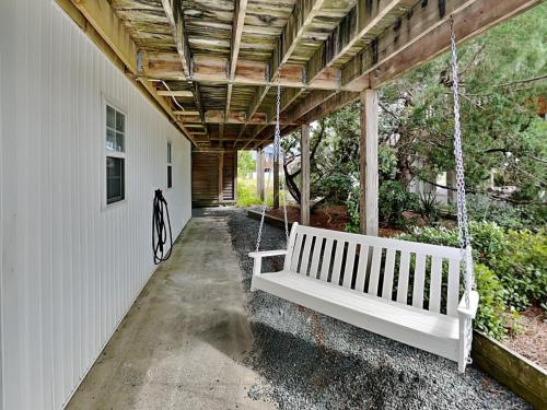 a white porch swing hanging from a building at The Sassy Sea Turtle in Hampstead