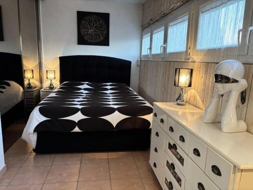 - une chambre avec un lit noir et blanc et une commode dans l'établissement Résidence Port Nature Colline 2 - Appartement T2- Port Nature Colline 2 Duplex MAE-2924, au Cap d'Agde