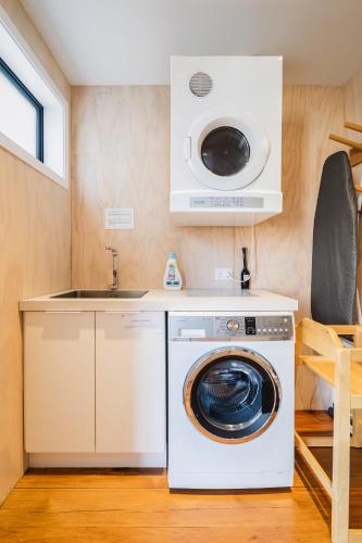 a kitchen with a washing machine and a sink at Mackenzie Crib in Lake Tekapo