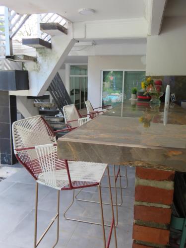 a kitchen with chairs and a large marble counter at Casa Hotel AeroClubR15 in Villavicencio
