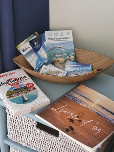 a book shelf with a bowl filled with books at Studio Tibiscus - Riviere Salée in Médecin