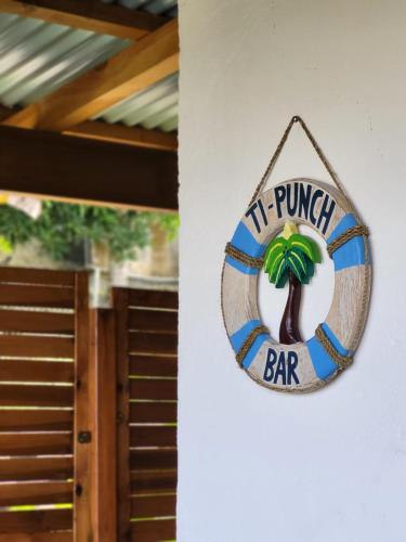a sign for a bar hanging on a wall at Studio Tibiscus - Riviere Salée in Médecin