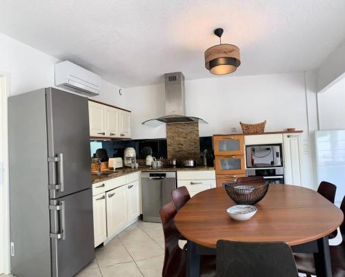 une cuisine avec une table en bois et un réfrigérateur dans l'établissement Résidence Port Nature Village 2 - Grande villa 6 Pers. Port Nature Village MAE-5501, au Cap d'Agde