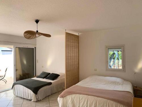 une chambre avec deux lits et un ventilateur de plafond dans l'établissement Résidence Port Nature Village 2 - Grande villa 6 Pers. Port Nature Village MAE-5501, au Cap d'Agde