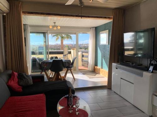 - un salon avec un canapé et une vue sur une terrasse dans l'établissement Résidence Port Nature Colline 4 - Appartement T2- Port Nature Colline 4 MAE-5261, au Cap d'Agde