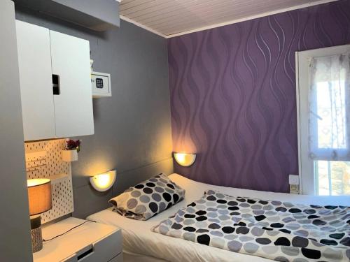 - une chambre avec un lit et un mur violet dans l'établissement Résidence Port Nature Colline 4 - Appartement T2- Port Nature Colline 4 MAE-5261, au Cap d'Agde