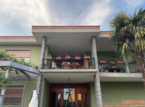 a house with a balcony with tables and chairs at Villa Fiorita in Mediglia