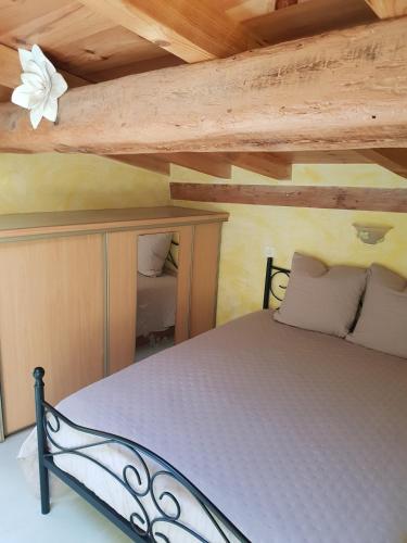 une chambre avec un lit dans une pièce avec des plafonds en bois dans l'établissement Le Récantou - Appartement Villelongue d 'Aude, à Villelongue-dʼAude