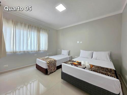 a bedroom with two beds and a window at 5 Quartos 4 Banheiros, na Vila A, a 5 min Paraguai in Foz do Iguaçu