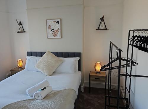 a bedroom with a bed with white sheets and two lamps at Large 4 Bed Home - Fast Wifi, Smart TV's & Free Parking - Near A66 in Stockton-on-Tees