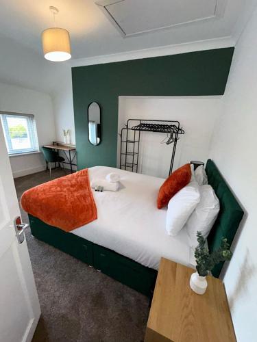 a bedroom with a large bed with a green wall at Large 4 Bed Home - Fast Wifi, Smart TV's & Free Parking - Near A66 in Stockton-on-Tees