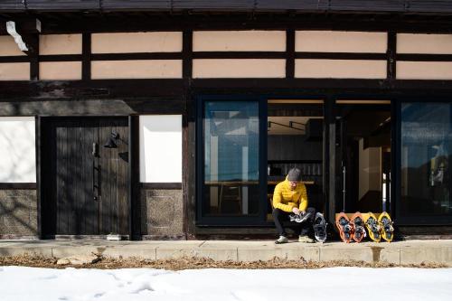 a person sitting on a sidewalk in front of a building at JINEN hida takayama in Machikata