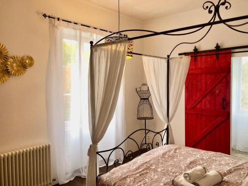 a bedroom with a red door and a bed at La Vergnotte B & B in Saint-Antoine-de-Breuilh