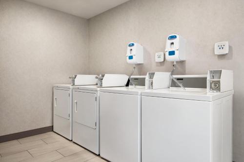 a row of washers and dryers in a room at Holiday Inn Express Syracuse Airport by IHG in North Syracuse
