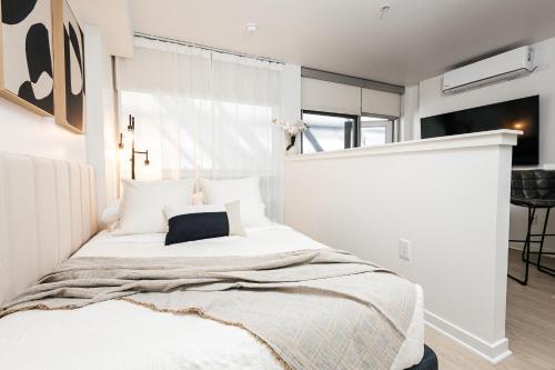 a bedroom with a white bed with a pillow on it at Seaside Serenity - Chic Santa Monica Studio in Los Angeles