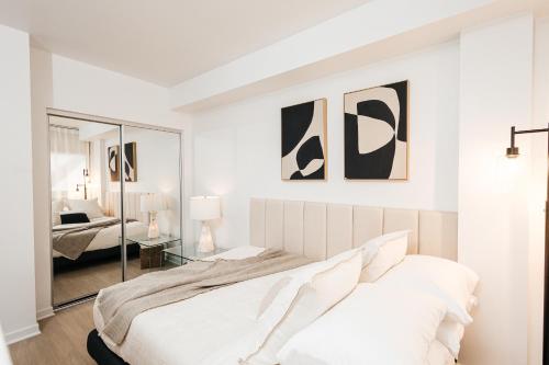a white bedroom with a bed and a mirror at Seaside Serenity - Chic Santa Monica Studio in Los Angeles