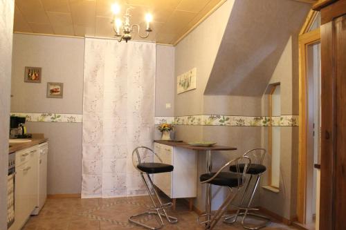 a kitchen with a table and two stools at Ferienwohnung Sabine in Zella-Mehlis