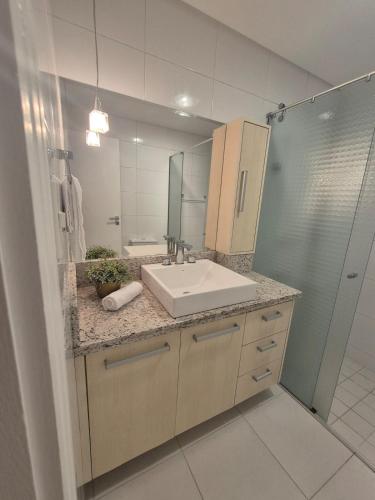 a bathroom with a sink and a mirror at Apartamento moderno e funcional bem localizado in Balneário Camboriú